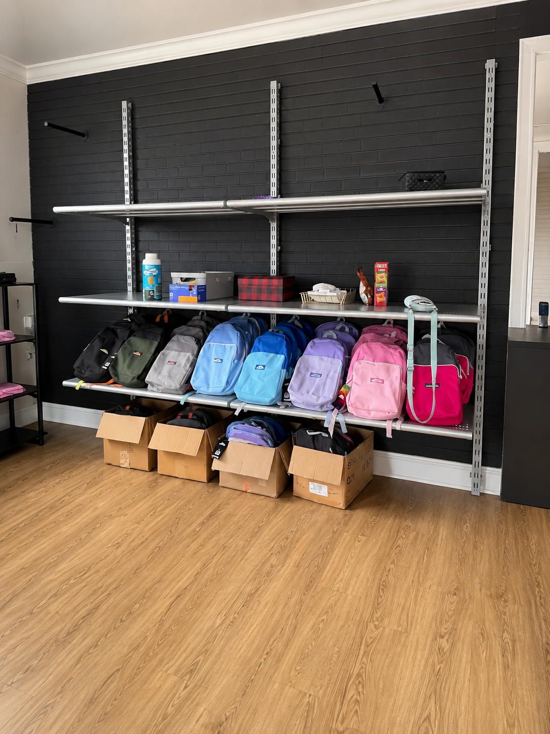 Colorful backpacks on shelves at Brady’s Closet